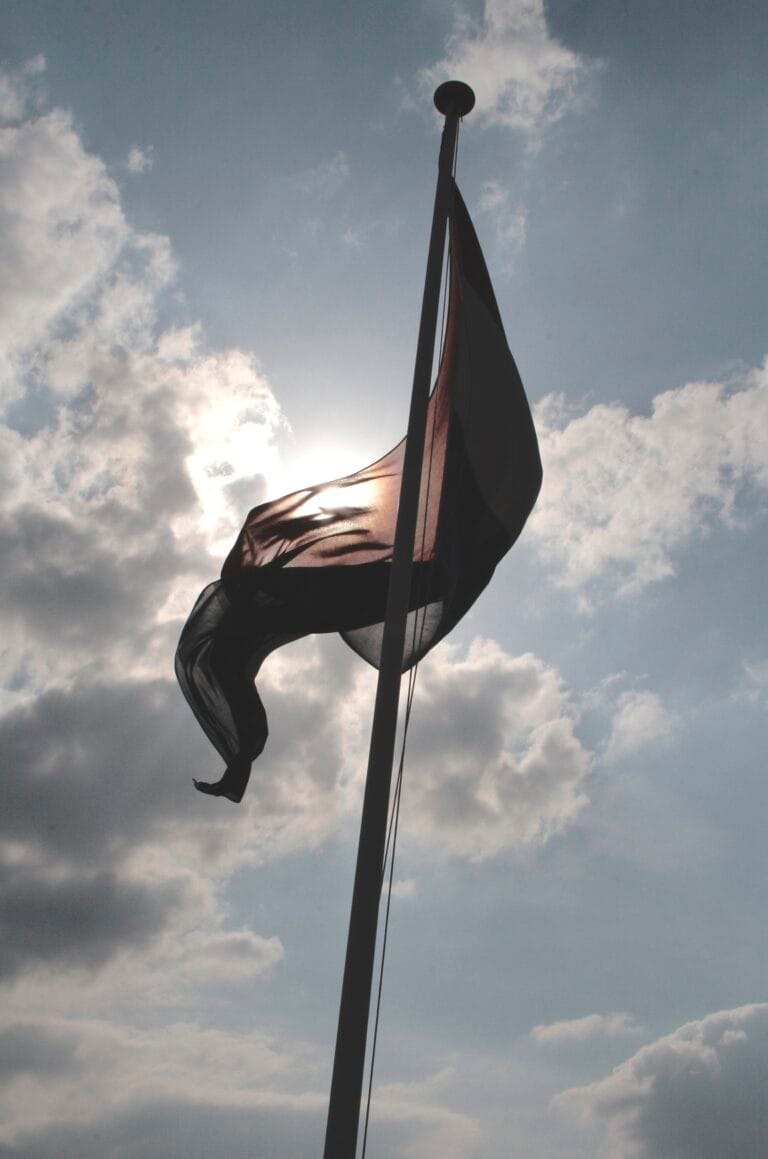 Un drapeau qui danse sur le souffle du vent au levé du soleil.